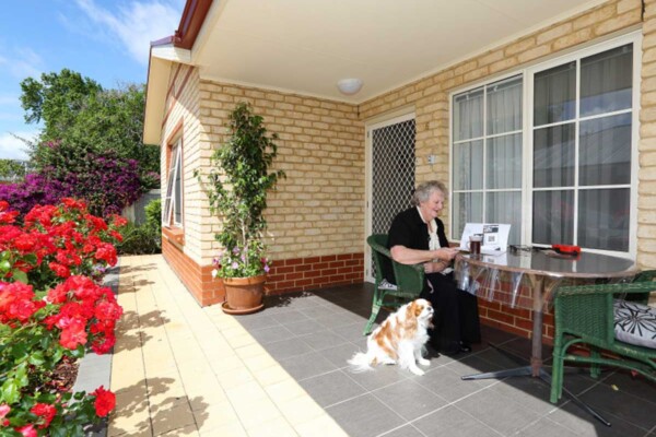 Resident reading on her front porch at Plympton Mews