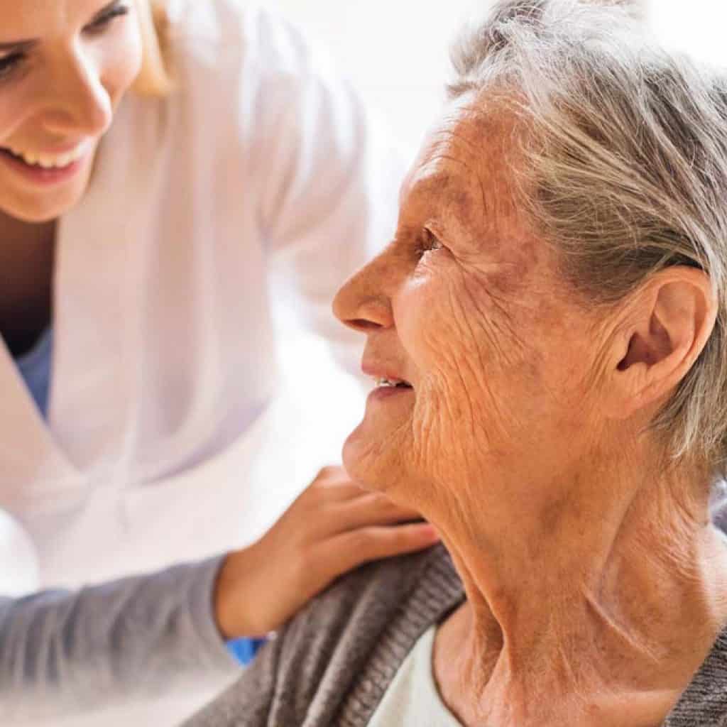 Health visitor and a senior woman during home visit.