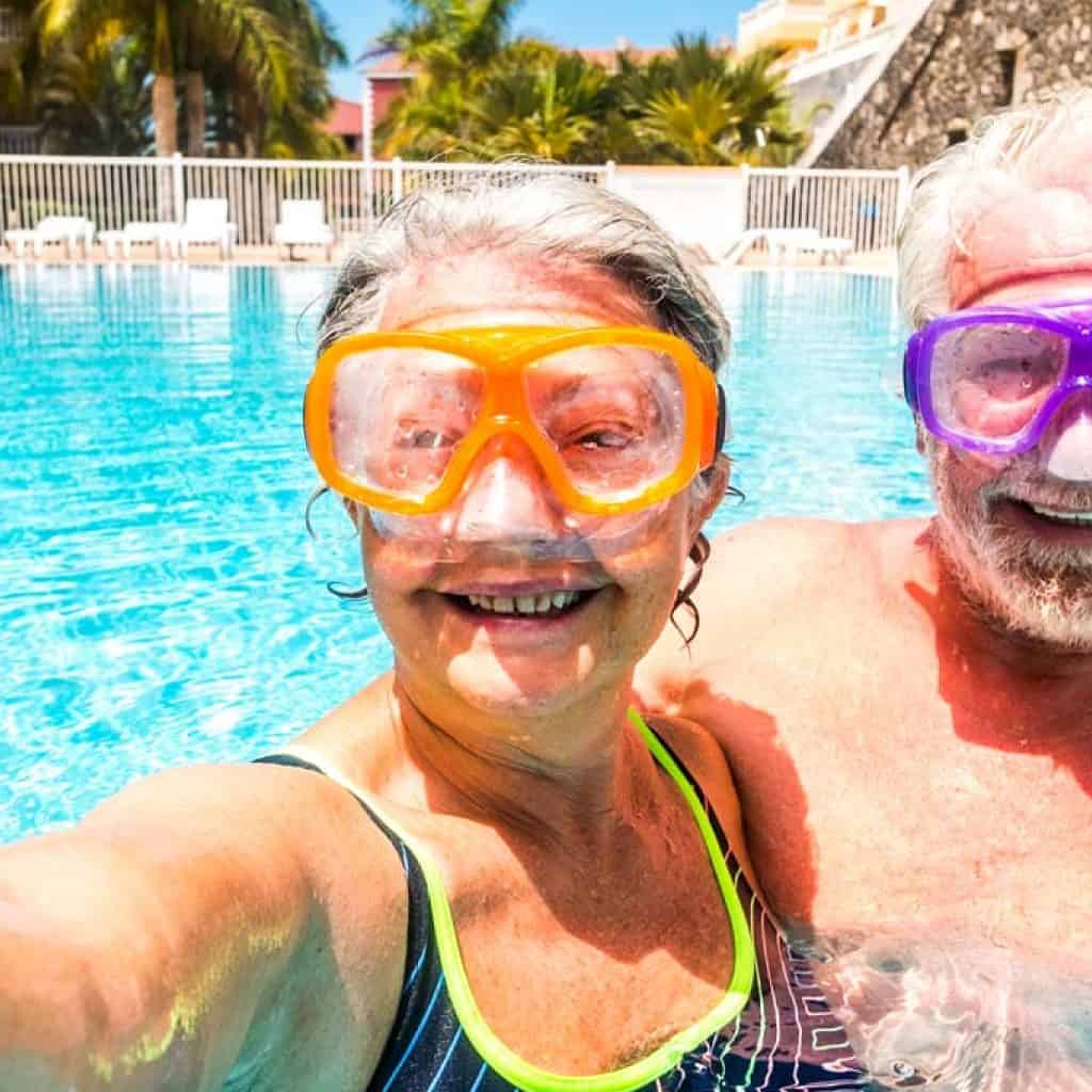 Happy cheerful people old senior man and woman have fun together in the summer swimming pool