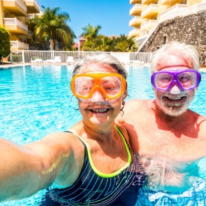Happy cheerful people old senior man and woman have fun together in the summer swimming pool