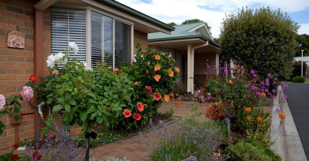 Retirement village street views showing quiet streets and views of housing units with well kept gardens with flowers.