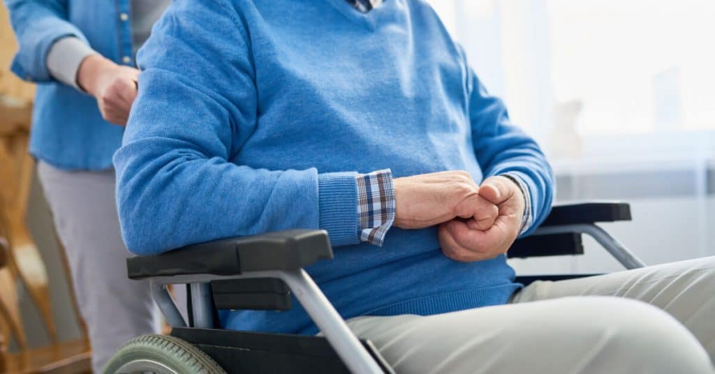 Mid-section portrait of woman pushing unrecognizable senior man in wheelchair, copy space